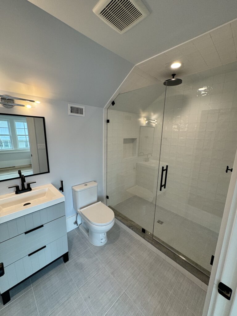 Finished bathroom remodel with walk-in glass shower, custom tile, vanity, and trim work by Alabaster Contracting Solutions in Greater Cincinnati and Southwest Ohio.