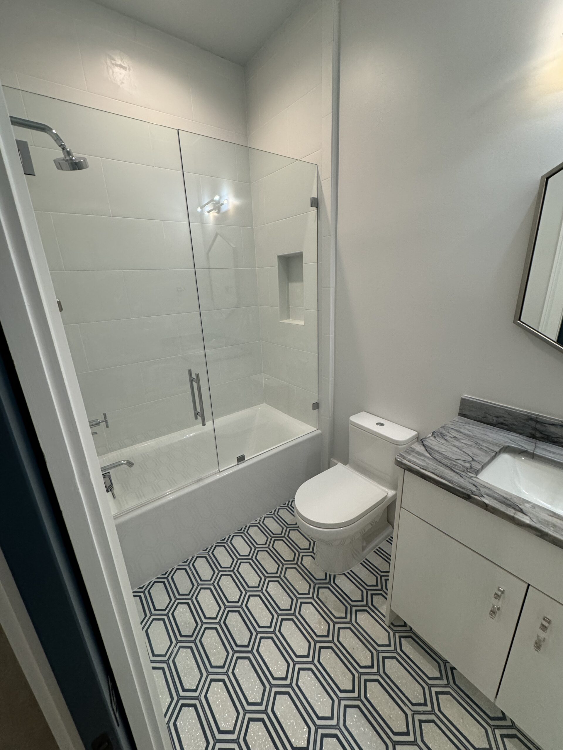 Full bathroom renovation with glass shower, bathtub, vanity, tile flooring, lighting, trim, and finish work by Alabaster Contracting Solutions